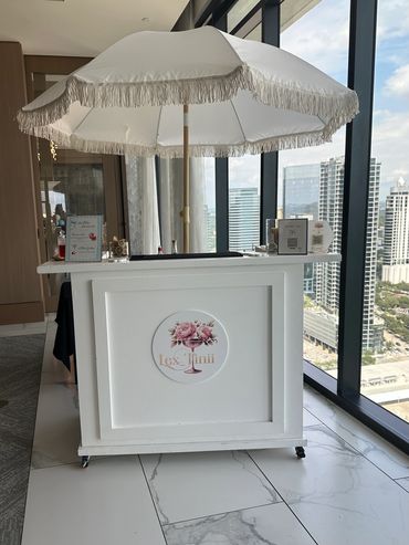 Cute mobile bar with umbrella, perfect for this baby shower set up. Custom Cocktails,