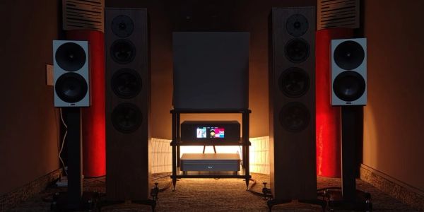 High-end audio system setup with speakers and amplifier in a dimly lit room.