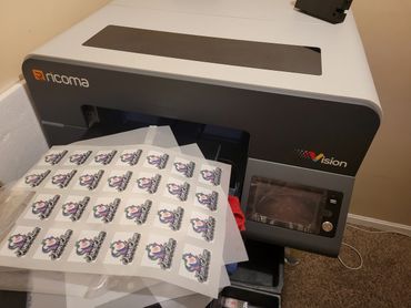 Ricoma Vision printer producing colorful custom patches on a sheet.