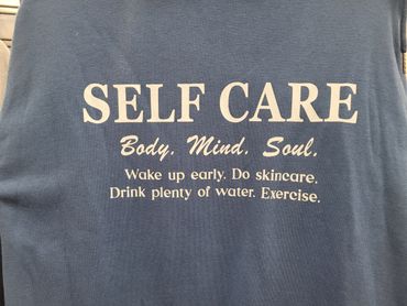 A shirt with a self-care message emphasizing body, mind, and soul.