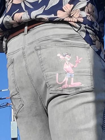 Gray jeans with a Pink Panther cartoon on the back pocket.