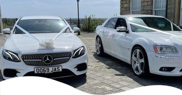Two wedding cars with ribbons.  A Mercedes Benz & a Chevrolet.