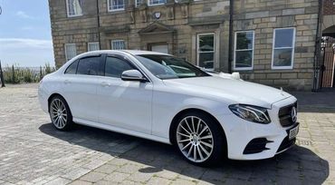A white modern Mercedes Benz saloon car limousine