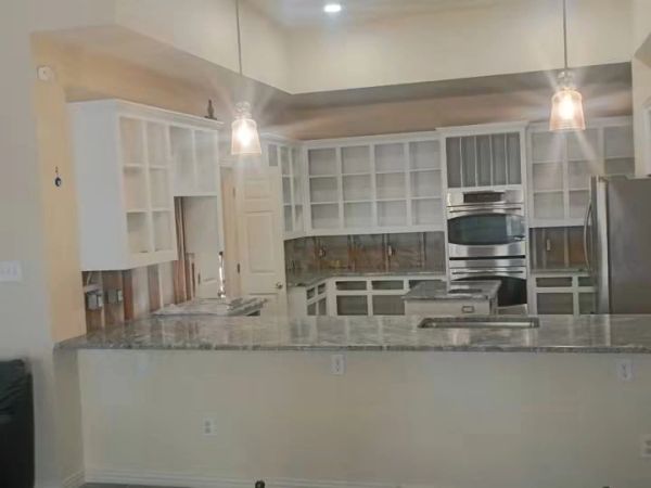Modern kitchen with white cabinets and granite countertops.