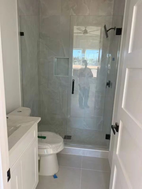 Modern bathroom with glass shower and white fixtures.