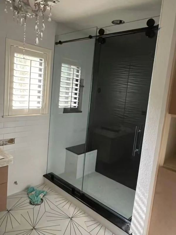 Modern bathroom with glass shower and geometric tile.
