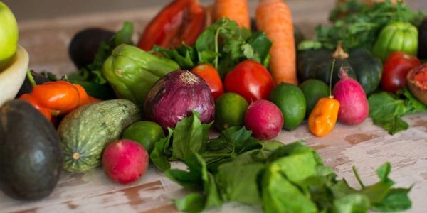 A colorful assortment of fresh vegetables including carrots, radishes, and onions.