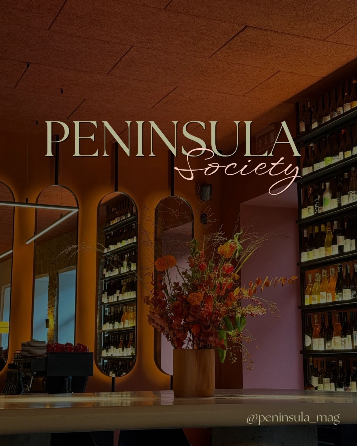 Elegant bar interior with warm lighting and floral centerpiece at Peninsula Society.
