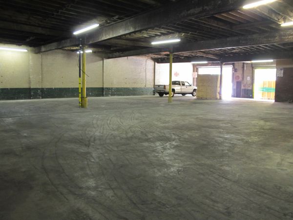 Empty warehouse interior with a white pickup truck.