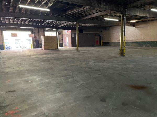 Empty industrial warehouse with concrete floor and pillars.