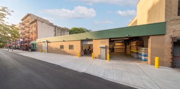 Building exterior with open garage and yellow bollards.