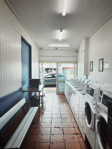 Interior of a laundromat with washing machines and benches.
