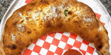 Large pizza turnover with sauce, inviting and appetizing