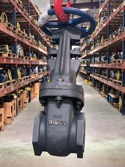 A large industrial valve labeled NIBCO in a warehouse aisle.