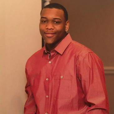 Young man smiling wearing a red shirt.