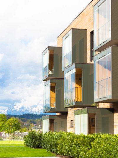 Modern apartments with glass balconies overlooking a scenic mountain view.
