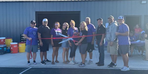 Group ribbon cutting ceremony outside a building.