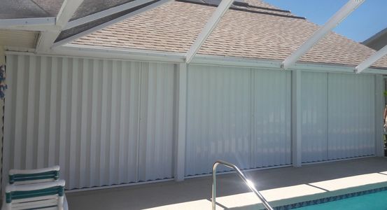Accordion hurricane shutters covering large patio