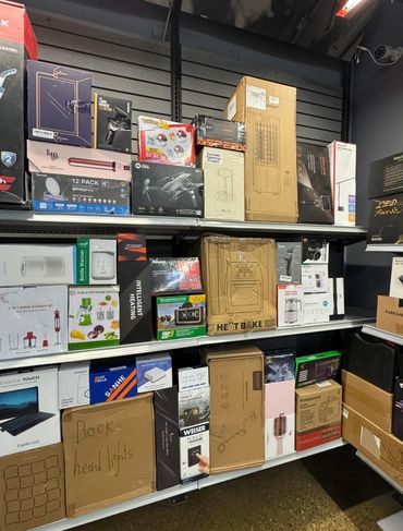 Shelves filled with various boxed electronic and household items in a store.