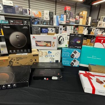 Assortment of boxed electronics and gadgets displayed on a table and shelves.