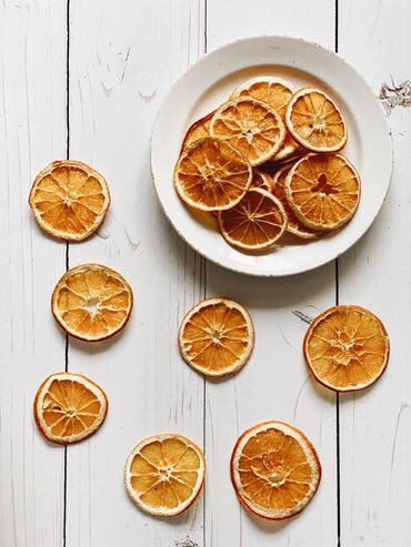Dried orange slices on a white plate and table.