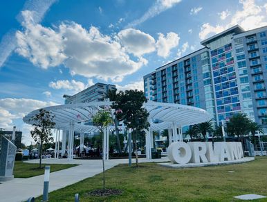 Modern park area with large ORLAND sign in front of buildings.