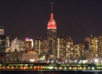 Night view of a city skyline with a brightly lit red tower.