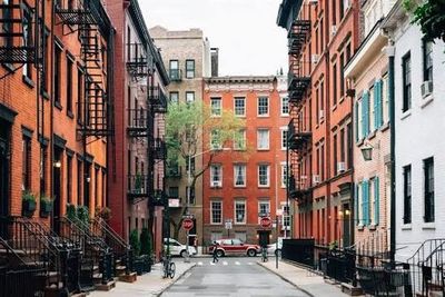 A quiet urban street lined with brick buildings and fire escapes.
