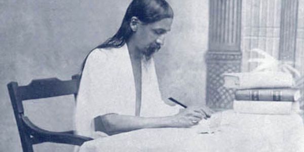 Sri Aurobindo writing at his desk (Sri Aurobindo Ashram)