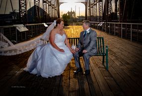 A bride and groom sitting on a bench