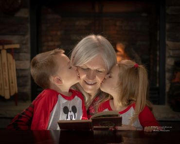 Two kids kissing their mom