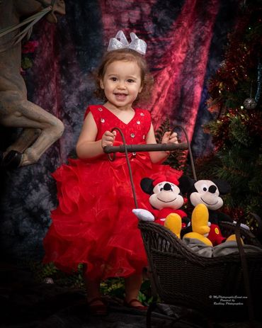 A girl in red with a Mickey Mouse stroller