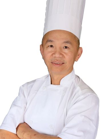 Chef Ray Gong, Executive Chef at Hong Kong East Ocean, in white uniform and tall chef hat.