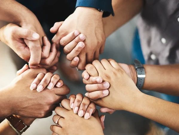 Diverse group holding hands in unity and support