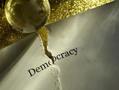 Piece of paper showing the word democracy, torn in half
