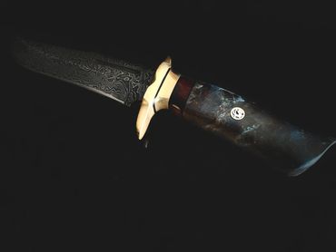 Damascus hunting bowie with burlwood and brass