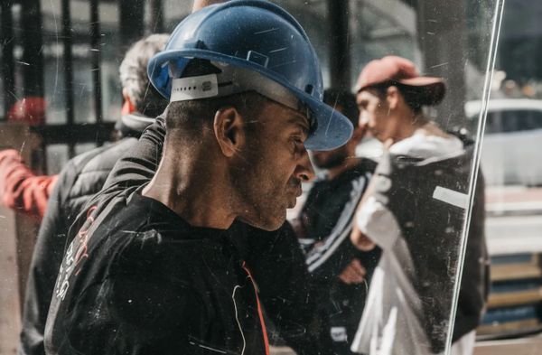 Construction worker in a blue helmet focuses intently at a work site.