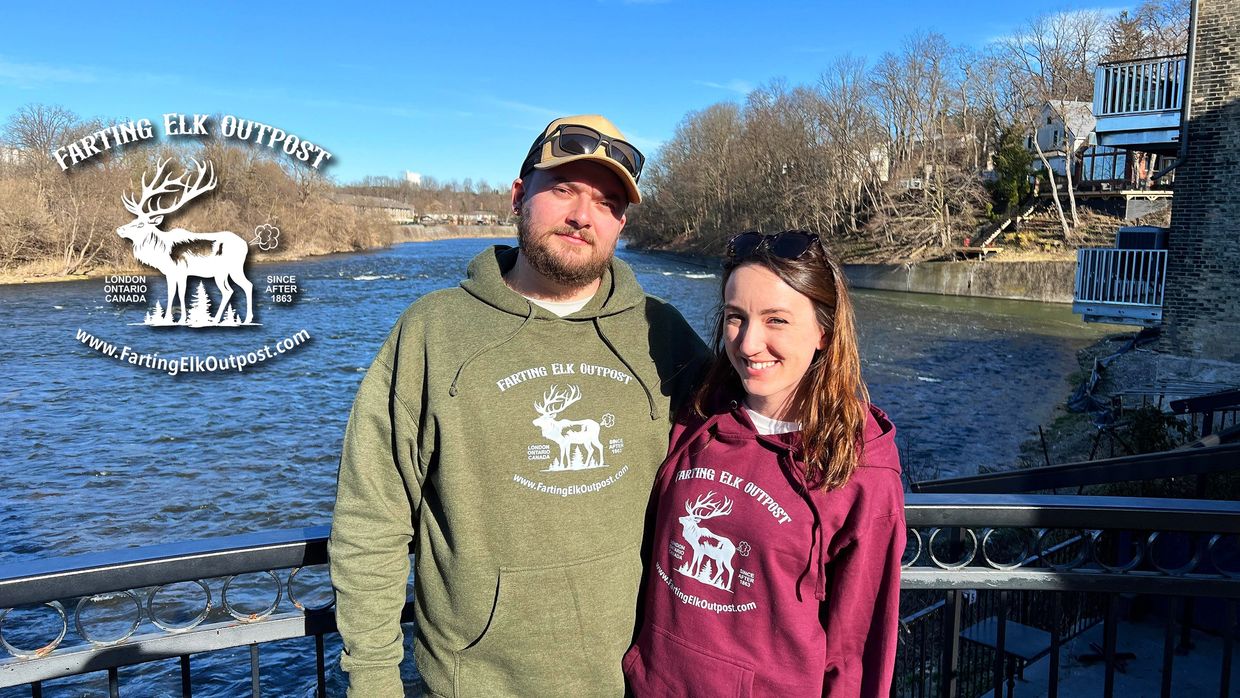 A young couple proudly wearing Farting Elk Outpost hoodies. Warm and cozy.