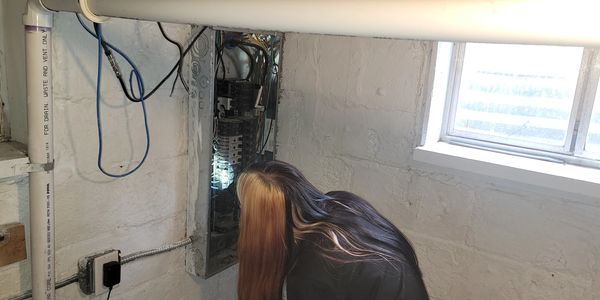 Gold Shield inspector evaluating an electrical panel during a professional home inspection in Easter