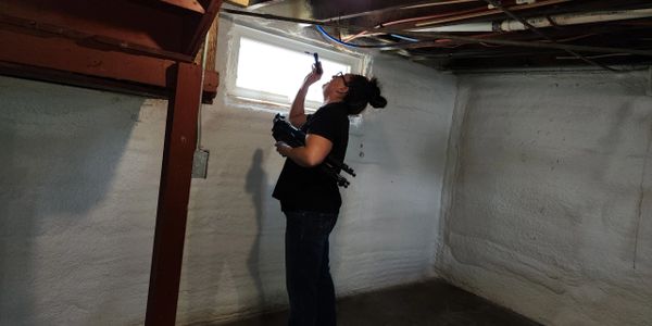 Gold Shield inspector evaluating basement structural and interior areas during a professional home i