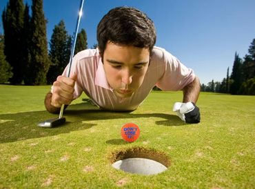 Golfer blowing the golf ball