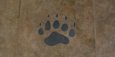 Waterjet cut tile inlay of a custom grizzly paw print for a home restoration in 2011.