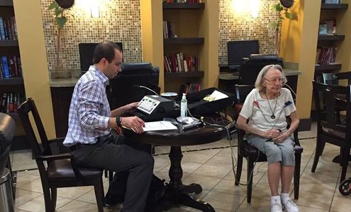 A man giving a woman a hearing test in her home.