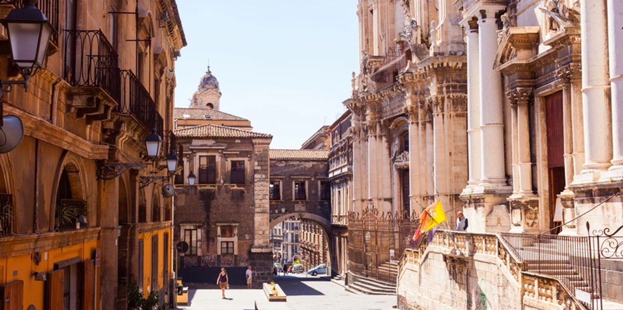 Historic European street with classic architecture and people walking.