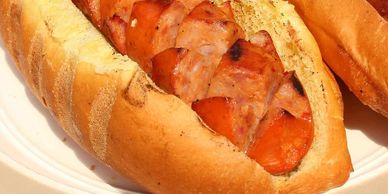 Two Hungarian sausage on a bun with crisscross cuts on a plate