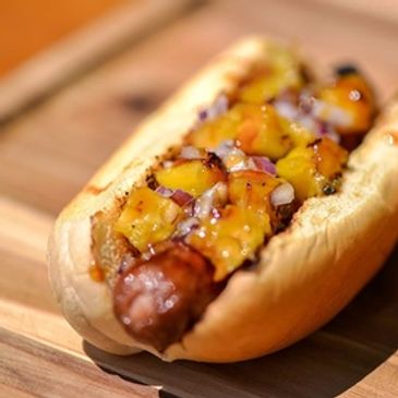Jumbo hot dog on a bun with fried onions and corn relish