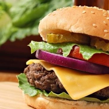 Thick Angus burger on a bun with cheese, lettuce, onion, tomato and pickle