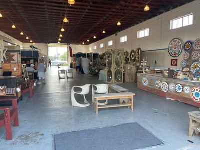 Indoor market with furniture and decorative plates on display.