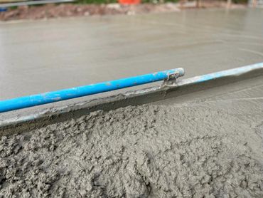 an image of concrete being poured and leveled