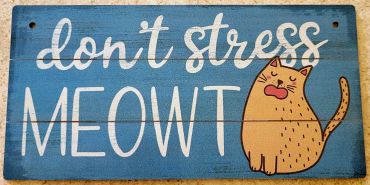 A blue sign with a cartoon cat and the phrase "don't stress MEOWT."